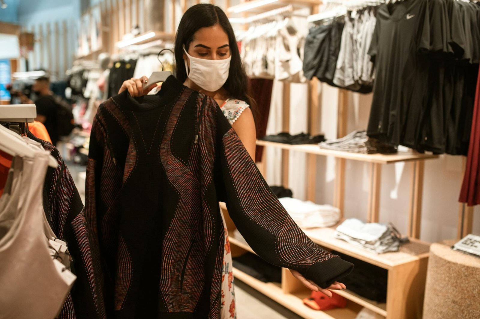 Woman wearing a face mask shops for clothes inside a store during the COVID-19 pandemic.